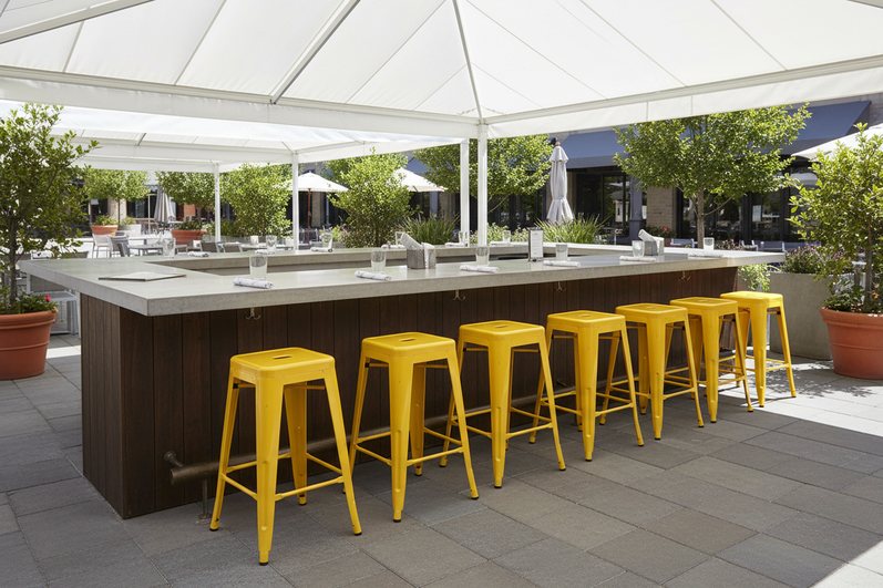 Outdoor restaurant counter service area with metal counter stools